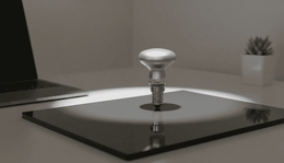 Ampoule réflecteur R39 posée debout sur une plaque de verre noir, au centre d'un halo de lumière sur un bureau