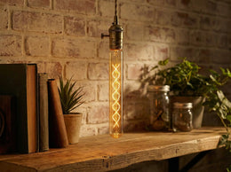 Ampoule tube T30 Robb allumée, suspendue au-dessus d'une étagère en bois devant un mur de briques blanchies