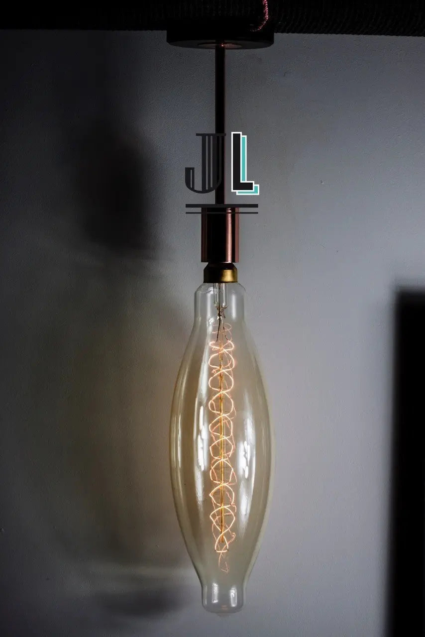 Ampoule Navett allumée en suspension verticale sous une douille cuivrée, filament spiralé sur toute la longueur